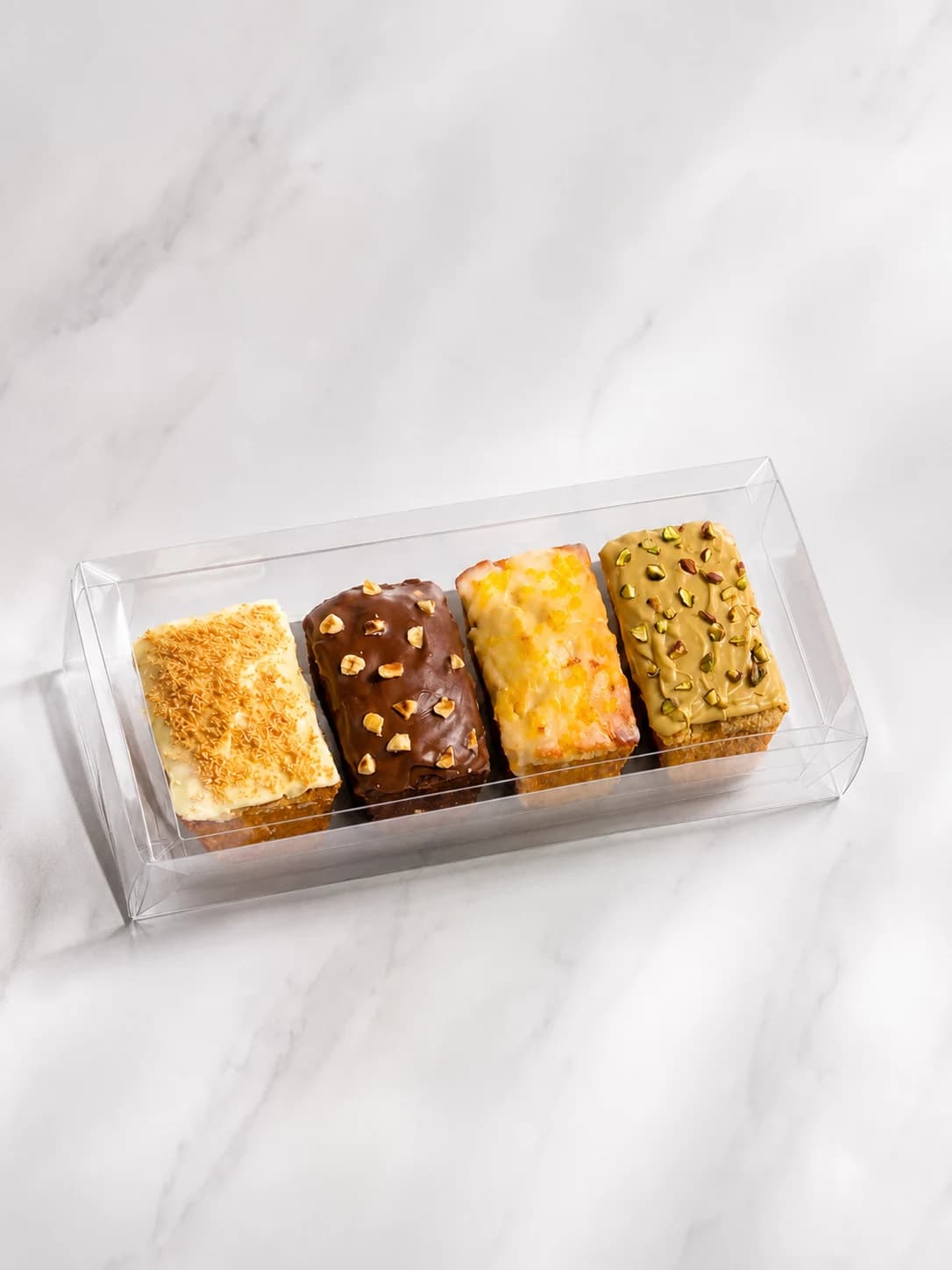 Coffret transparent contenant quatre cakes de voyage glacés